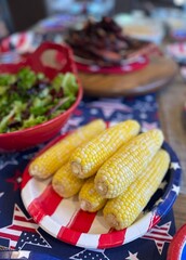 Fresh, shucked corn on the cob ready to eat with red, white, and blue decor