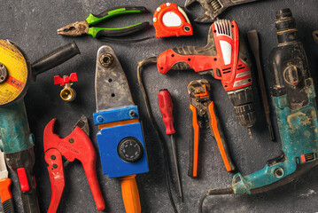 Dirty used construction worker tool on a dark background top view. Hard work concept