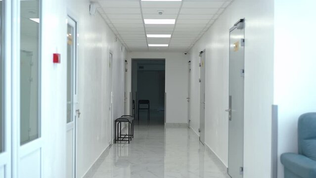 Empty hospital corridor with no people indoors. Wide shot white clean modern medical clinic with nobody inside. Concept of service and health care