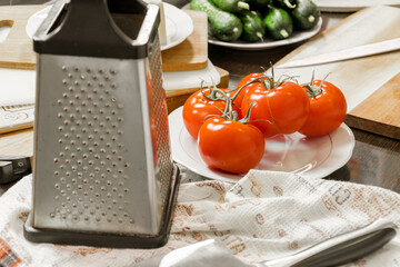 On the table are tomatoes, cucumbers, carrots, cheese, bread in a basket, herbs, dill, green onions, a knife on the board