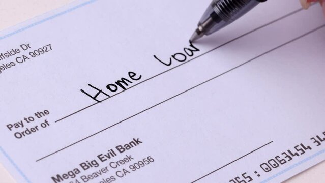 Close-up shot of a check being writen for a home loan.