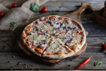 Pizza with tuna and red onion on old wooden table