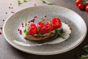 bruschetta with salmon and avocado cream on brown plate macro close up
