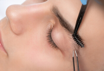 The makeup artist plucks the eyebrows of a handsome young man. Professional make-up and face care.