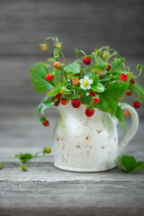 Ripe strawberries, bouquet in a small white jug