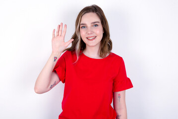 young caucasian woman wearing red T-shirt over white background showing and pointing up with fingers number five while smiling confident and happy.