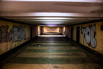 Underground pedestrian crossing with graffiti on the walls on both sides