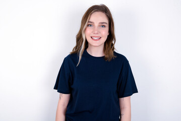 Fototapeta premium young caucasian woman wearing black T-shirt over white background with nice beaming smile pleased expression. Positive emotions concept