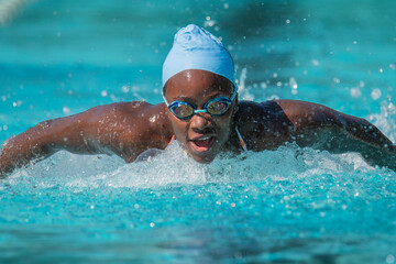 Young african american woman swimming butterfly