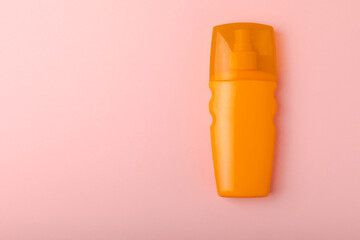 Sunscreen on a pink background. Plastic bottle of SPF sunscreen. Sunscreen selection.Summer travel beach flat lay composition, banner. Summer vacations and spf uv-protecting skin care concept.