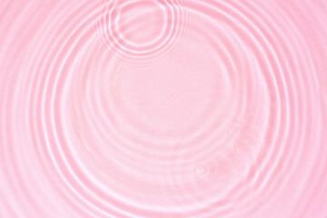 Cosmetic pink water texture, pink water surface with rings and ripples. Spa concept background