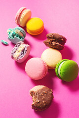 Bright colorful various flavor macarons sweet cookies on high-colored pink background