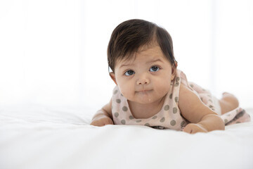 cute baby crawling on bed and drooling from mouth