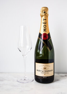 MOSCOW, RUSSIA - DECEMBER 10, 2018: Mo&euml;t & Chandon Imperial Champagne Bottle and One Glass on White Wall Background. Product of France.