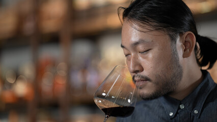 Night club concept of 4k Resolution. Asian man tasting wine in a restaurant. A group of specialized clubs that sell alcoholic beverages.