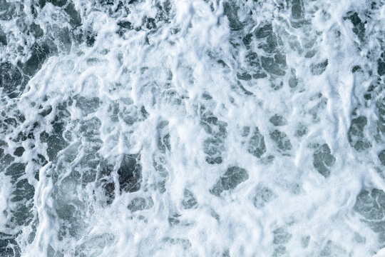 Sea water texture with splashes and foam, top view