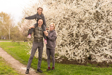 family in blooming garden with trees.