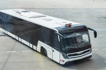 Bus in the parking lot for transporting passengers from the airport terminal building to the aircraft and vice versa.
