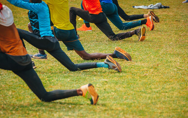 Stretching and warm-up of African runners. Joggers and marathon runners prepare to run on green grass. Photo from training in Kenya