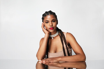 African American young woman with long dark braids, posing indoor. Mock-up.