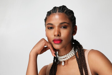Close-up of African American woman with long dark braids, posing indoor. Mock-up