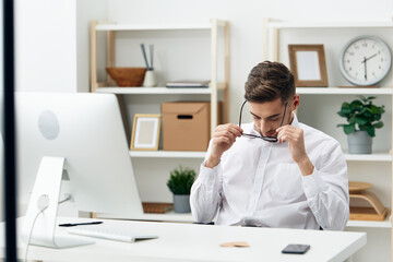 handsome businessman in a white shirt sits at a computer work office