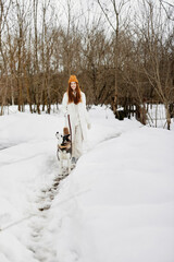 Fototapeta na wymiar young woman in the snow playing with a dog husky fun friendship winter holidays