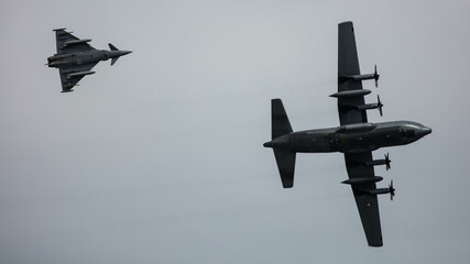 Eurofighter Typhoon and Hercules Transporter turning pass 