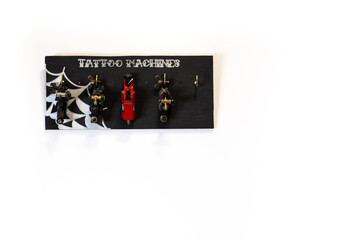Top view of four different tattoo machines on a black surface