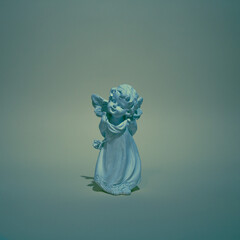 Sculpture of  blue angel  on background. Flat lay concept.