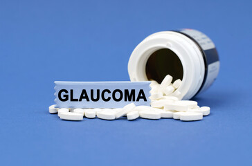 On a blue surface lies a jar of pills and a sign with the inscription - GLAUCOMA