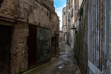 Fototapeta na wymiar An empty path with old derelict houses in the center of Gargano, Italy
