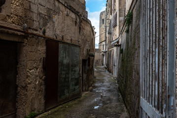 An empty path with old derelict houses in the center of Gargano, Italy