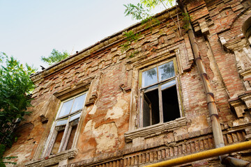 an old ruined building against the sky. broken glass in the windows.