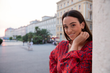 Portrait of a smiling woman on vacation in italy during sunset, happy caucasian girl.