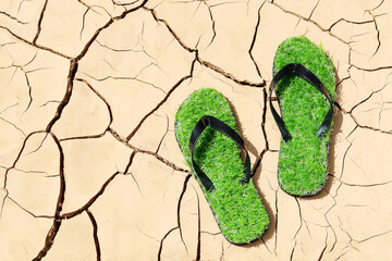 Soil erosion, green slippers with grass immitation, concept of drought, environmental problems and climate, in flat lay close-up
