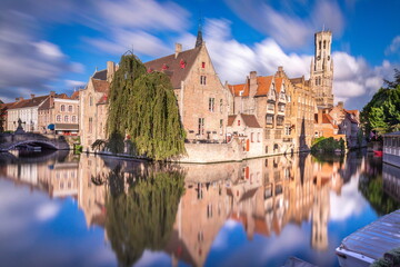 Fototapeta premium Rozenhoedkaai canal reflection at sunrise and blurred clouds, Bruges