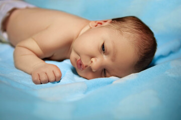 little newborn baby on a blue blanket