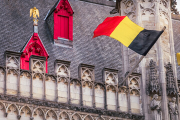 Fototapeta na wymiar Belgian flags, flemish architecture in Bruges market square