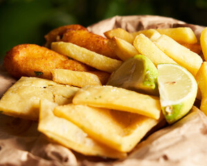 Tasty french fries with lemon on wooden table background. Food concept