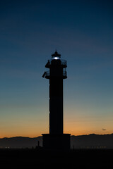 Lighthouse silhouette in Delta de l'ebro Spain during the sunset