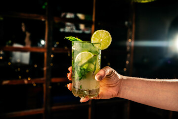 coctel de mojito sostenido en mano 