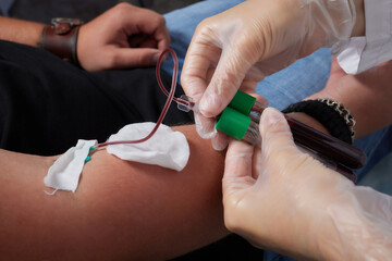 the doctor collects blood in a syringe, Nurse takes blood from the veins on the arm.