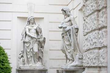 Fototapeta na wymiar Statue of Drave and Inn in Austria, marble statues in the castle park near white wall