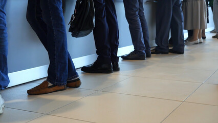 View of legs of customers standing n the modern office, getting served in the bank. Media. People...
