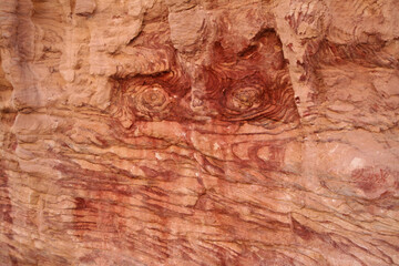 Red rock. Red eyes on the wall. Fancy abstract pattern on the rock. Stone texture