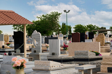 Modern gravestones at a public Jewish cemetery in Israel on a sunny day. Memory stones on judaic...