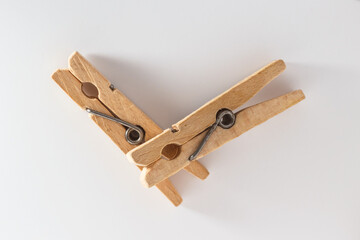 Two wooden clothespins on a white background