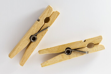 Two wooden clothespins on a white background