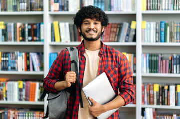 Happy confident indian or arabian male student of university, in stylish casual wear, with backpack...